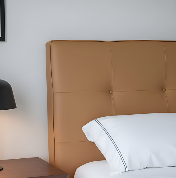Black table lamp on a nightstand next to a bed with a brown headboard and white pillows.